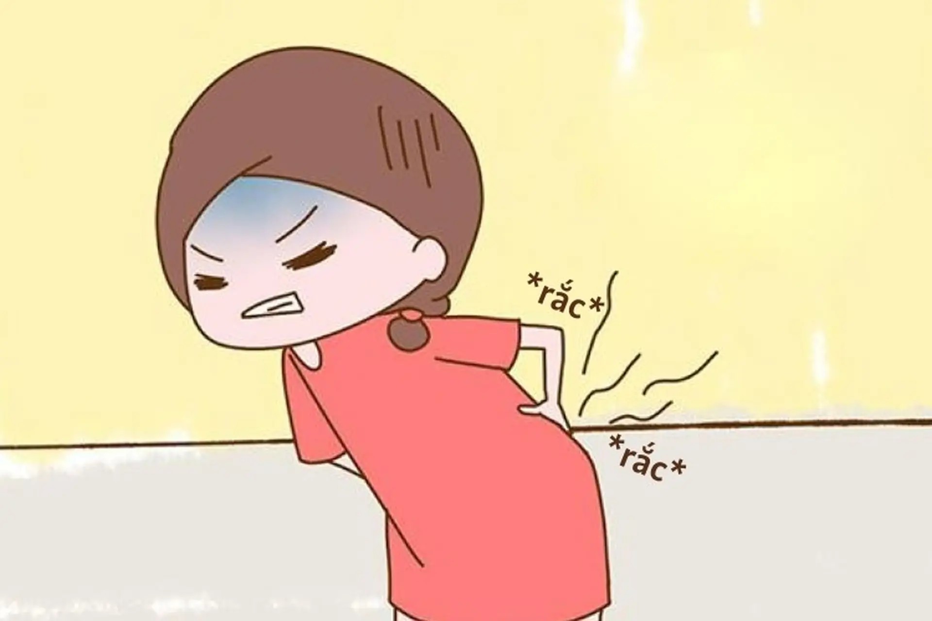 Một người đàn ông trẻ tuổi với tư thế ngồi làm việc không đúng đang biểu lộ sự đau mỏi lưng