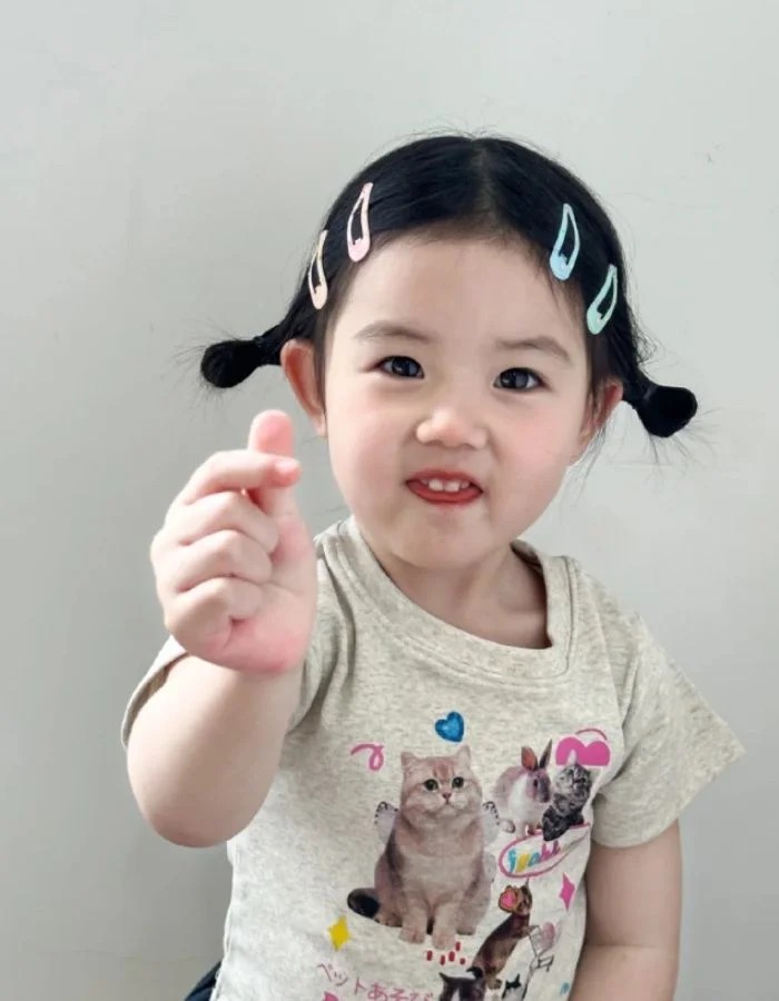 Bé Thương Thương với cử chỉ bắn tim hài hước