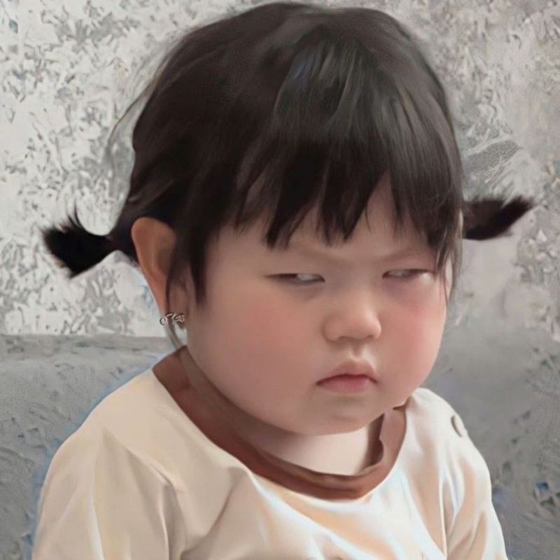 Một em bé đang tỏ vẻ không vui với đôi má phồng