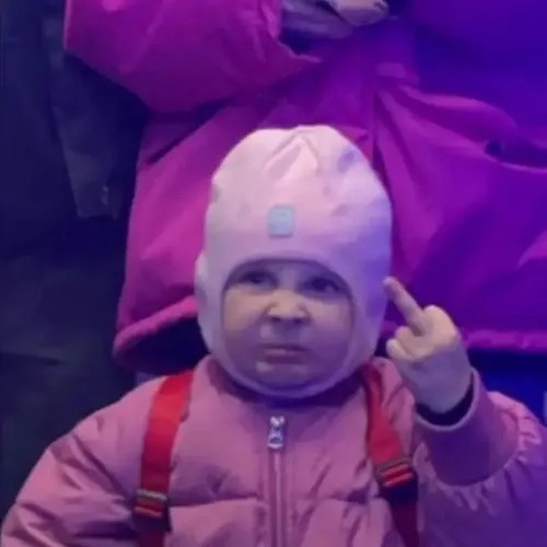 Meme em bé dơ ngón fuck với ánh mắt cau khó chịu.